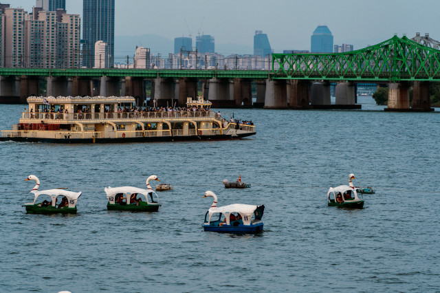 (3-2) 여의도한강공원_해 질 녘 한강 파라다이스 건물 전망대에서 바라본 풍경. 한강유람선이 한강철교를 향해 가고 있다. 오리배는 한강 파라다이스 건물에서 탈 수 있다..jpg