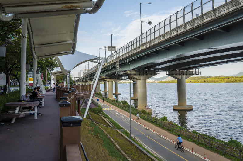 4-2. 광진정보도서관 앞 ‘광나루 낭만의 거리’ 데크 쉼터에서 주민이 담소를 나누고 있다..JPG